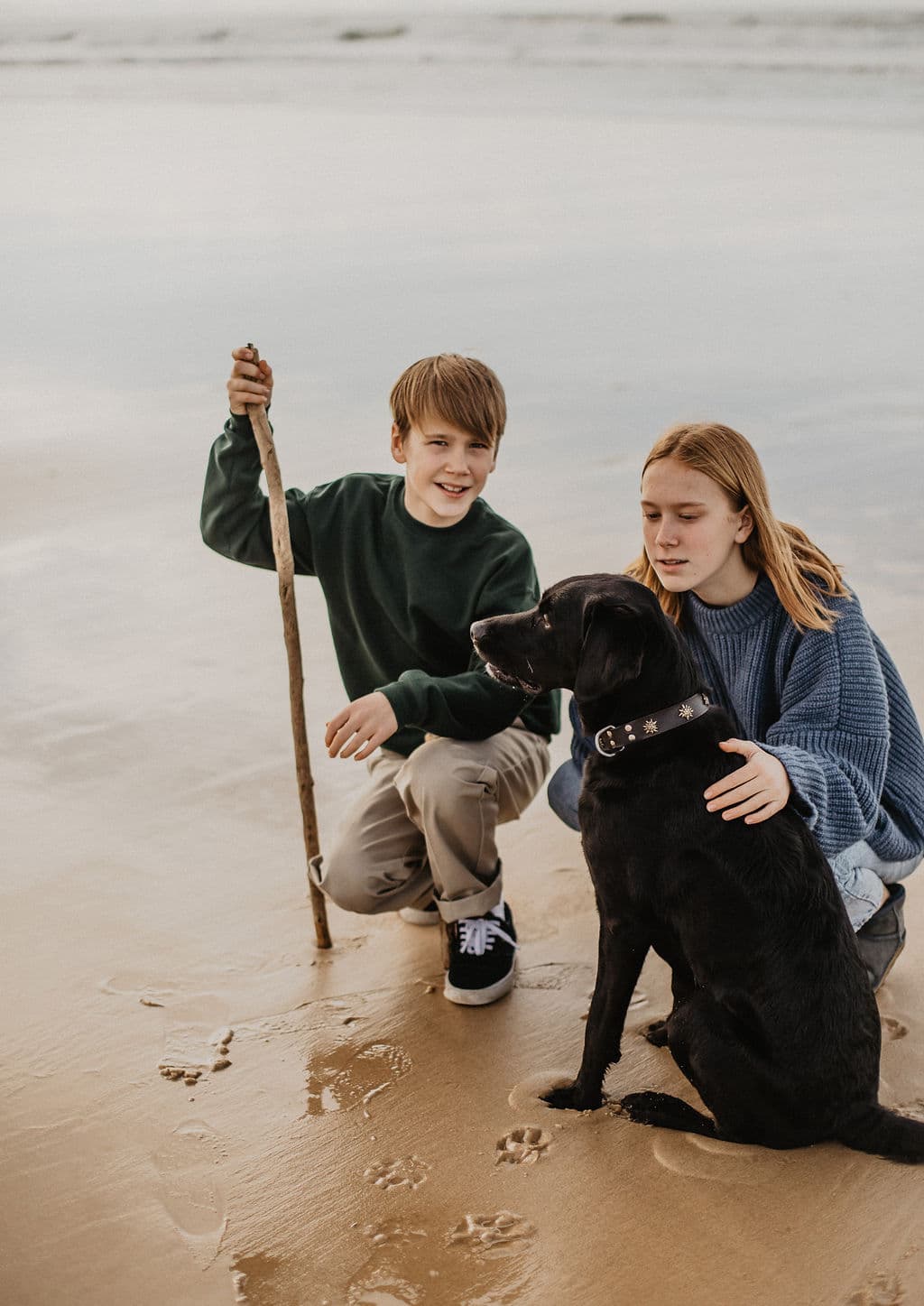 deux enfants sur la plage avec leur chien labrador pour Maison Medor